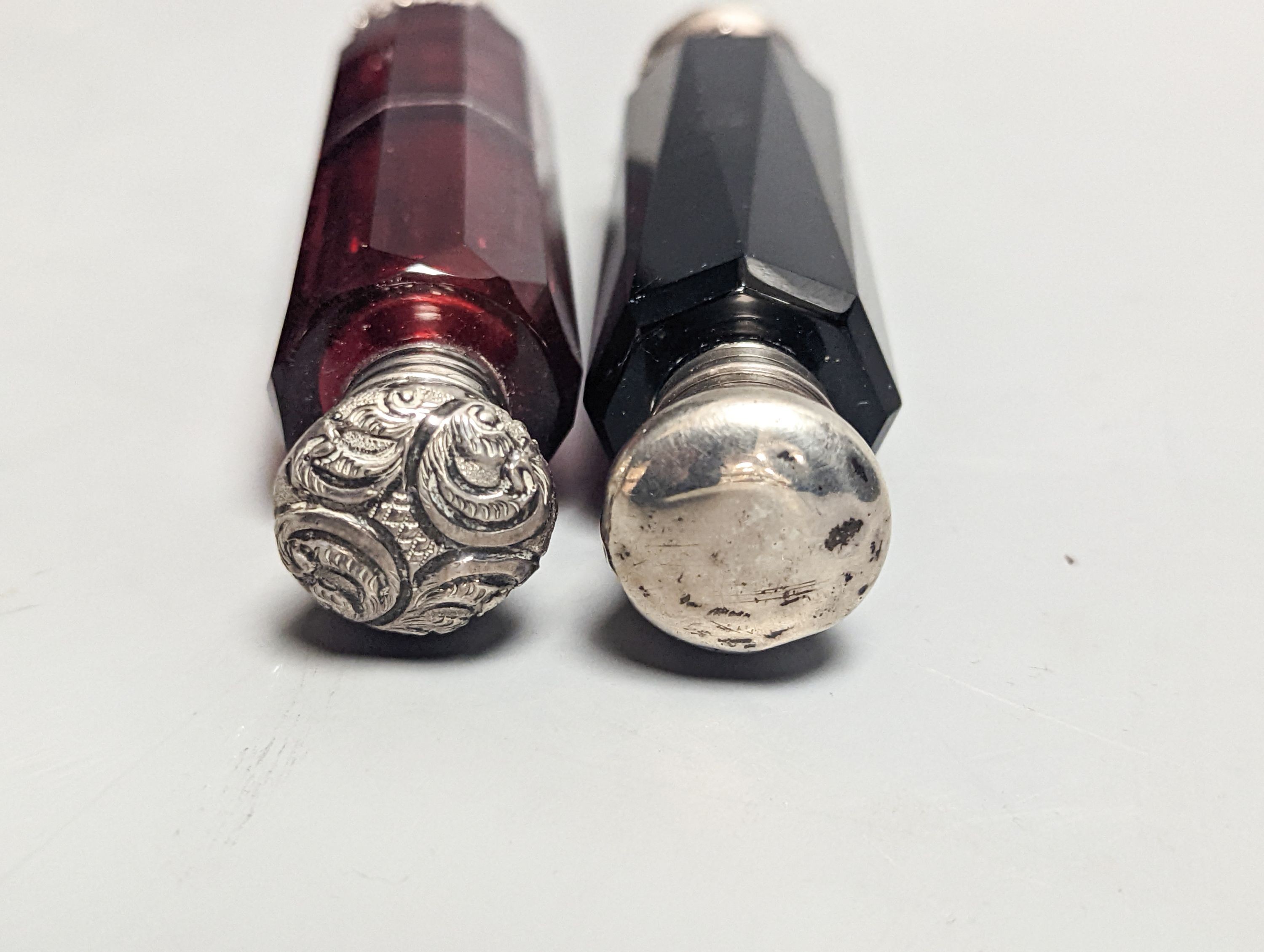 Two Victorian white metal mounted green or ruby glass double ended scent bottles, largest 13cm.